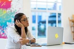 woman sitting at computer looking bored